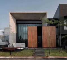 a modern house with wooden doors and steps leading up to it