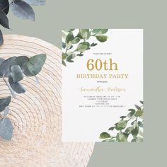 an elegant birthday party with greenery and gold foil on the front, along with a white card that reads'60th birthday party '