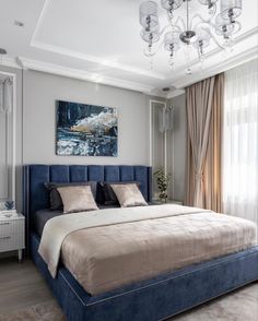 a bedroom with a large bed and chandelier hanging from it's ceiling