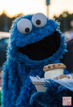 the cookie monster is holding an ice cream sandwich