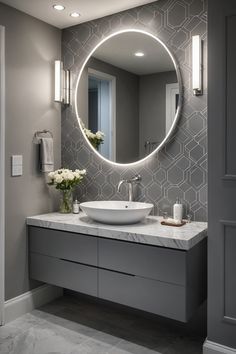 Modern bathroom with a round backlit mirror, gray geometric tile backsplash, and floating vanity with marble countertop. Bathroom Ideas Light Grey, Classic Gray Bathroom, Gray Bathroom Decor Ideas, Bathroom Ideas Grey, Grey Tile Bathroom, Modern Bathroom Design Grey, Gray Bathroom Ideas, Modern Washroom Design, Gray Bathrooms