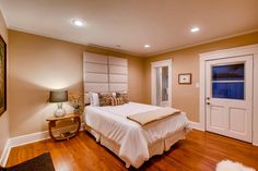 a large bed sitting inside of a bedroom on top of a hard wood floored floor