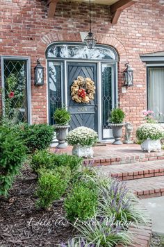 a front door with flowers and wreaths on it