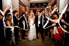 a bride and groom walk down the aisle as confetti is thrown around them