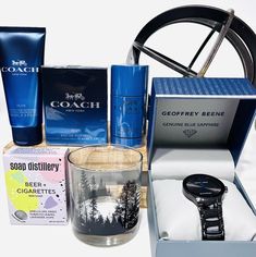 an assortment of men's personal care items including a watch, cologne bottle and soap