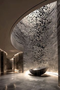 an artisticly designed bathroom with stone walls and flooring is lit up by lights