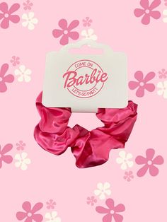 pink scrunffle hair tie with barbie logo on it