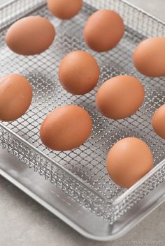 six eggs in a metal tray on a table