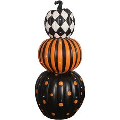 three pumpkins stacked on top of each other in black and orange striped designs with polka dots