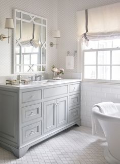 a white bathroom with two sinks and mirrors