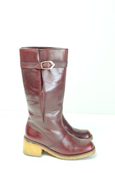 Vintage 70's Etienne Aigner burgundy leather boots.  Knee high.  Slightly rounded square toes.  Buckle at the calf.  Textured rubber sole.  Condition: Very good condition.  Only light wear.Brand: Etienne AignerMaterial: Leather upper, rubber soleSize: 5 1/2Length inside from heel to toe: 8 3/4 in.Heel width inside: 2 1/4 in.Ball outside: 2 7/8 in.Boot height: 11 1/2 in.Calf circumference: 12 1/2 in. Fall Burgundy Boots With Leather Lining, Vintage Boots With Leather Sole And Square Toe, Retro Leather Boots With Square Toe, Retro Square Toe Leather Boots, Burgundy Leather Square Toe Boots, Vintage Leather Boots With Low Heel, Vintage Leather Heeled Boots With Low Heel, Vintage Wide Calf Mid-calf Boots With Round Toe, Vintage Mid-calf Leather Boots