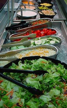 a buffet line filled with lots of different types of salads