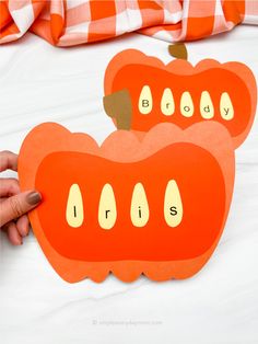 two orange paper cutouts with words that spell out the word, buddy and lips