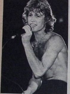 an old photo of a shirtless woman singing into a microphone