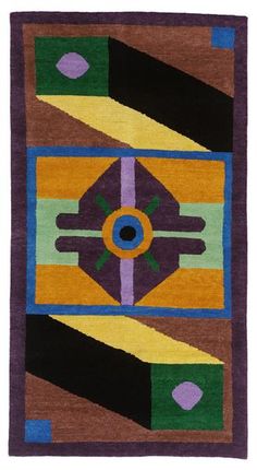 a colorful rug with an eye on it's center and purple, green, yellow, blue, and orange colors