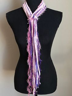 a black mannequin with a purple and white scarf on it's neck