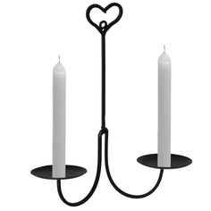 two white candles are in the shape of hearts on a black stand with a heart - shaped candle holder