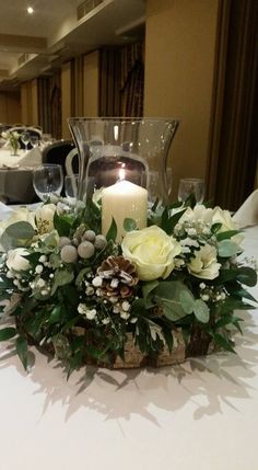 a centerpiece with flowers and candles on a table