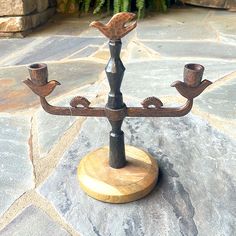 a metal candelabra sitting on top of a stone floor