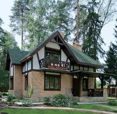 a small brick house with a green roof