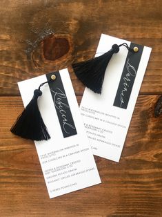 two black tasselled bookmarks with the word love written on them, sitting next to each other