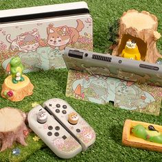 there are many toys and games on the green carpeted floor in front of an electronic device