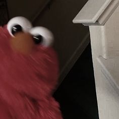 a close up of a person wearing a red sesame character costume and holding something in their hand