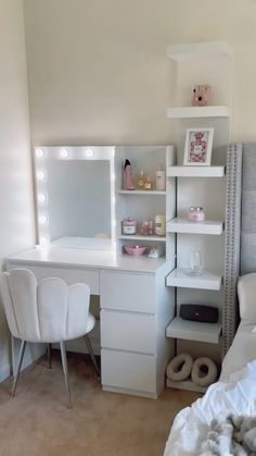 a bedroom with a bed, desk and mirror in the corner that has lights on it