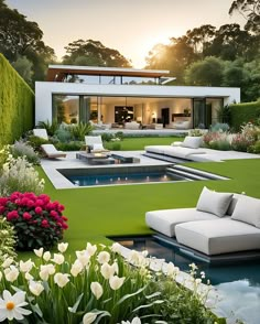 an outdoor living area with white furniture and flowers in the foreground, surrounded by greenery