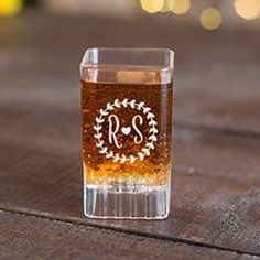 a shot glass sitting on top of a table with the initials r and s etched in it