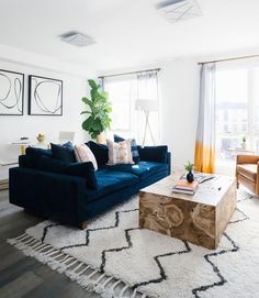 a living room with blue couches and white rugs