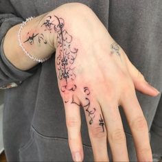 a woman's hand with tattoos on it