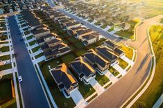 an aerial view of houses and roads in a residential area, with the sun shining on them