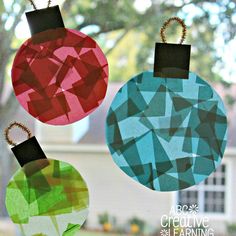 three christmas ornaments hanging from a window in front of a house with the words abc creative learning on it