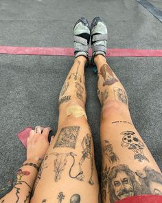 two people with tattoos on their legs sitting next to each other in front of a parking lot