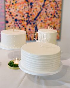 two white cakes sitting on top of a table