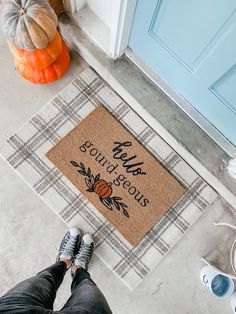 someone is standing on the front porch with their feet propped up next to a welcome mat