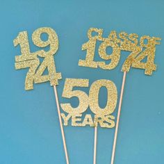 some gold glitter numbers are on top of cake sticks with the number fifty years written in them