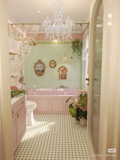 the bathroom is decorated in pastel pinks and greens with chandeliers hanging from the ceiling