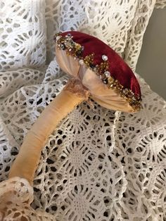 a close up of a mushroom on a lace table cloth with beads and pearls around it