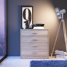 a room with a blue carpet and a lamp on top of a dresser next to a window