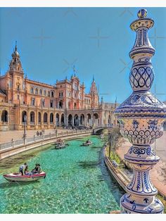 people in small boats on the water near a large building