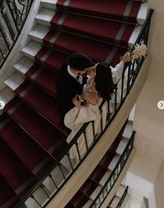 a bride and groom are kissing on the stairs