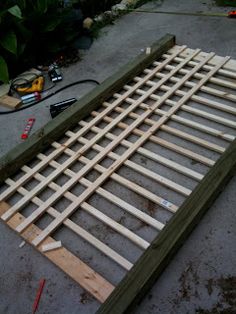 an unfinished bed frame laying on the ground