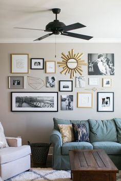 a living room filled with lots of framed pictures on the wall next to a couch