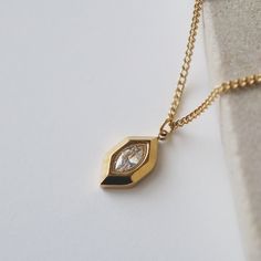 Introducing our Marlow Necklace, a testament to timeless elegance and refined minimalism. The marquise shape gracefully frames a CZ stone, adding a touch of sparkle and radiance. Its minimalistic style makes it perfect for any occasion.  -stainless steel, gold plated -15.5" with 2" extender Elegant Everyday Diamond-shaped Jewelry, Elegant Teardrop Jewelry With Diamond Eyes, Minimalist Marquise Wedding Necklace, Marquise Necklace, Minimalistic Style, Cubic Zirconia Necklace, Jewelry Case, Cz Stone, Pearl Ring