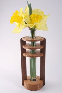 a vase filled with yellow flowers on top of a wooden stand