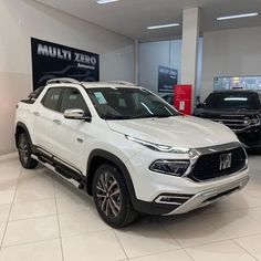 a white suv is parked in a showroom