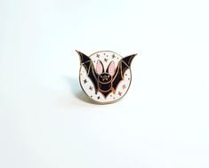 a bat pin sitting on top of a white surface