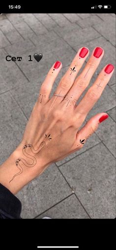 a woman's hand with red fingernails and tattoos on her left hand, which is drawn